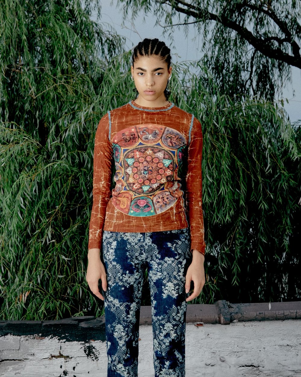 Person in patterned shirt and pants standing in front of a tree, representing content creation